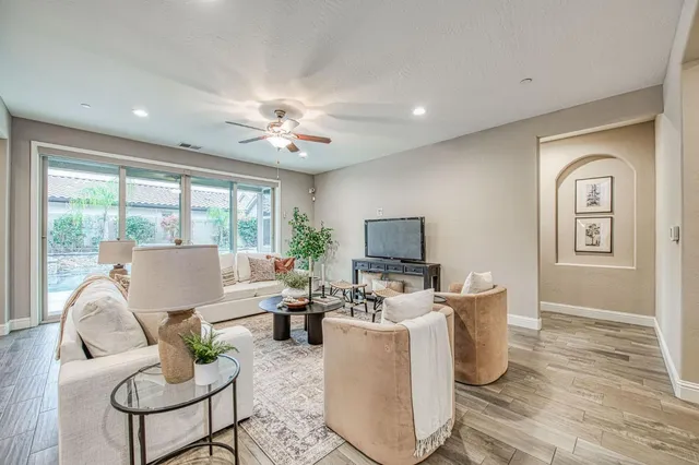 a living room with furniture a large window and a flat screen tv