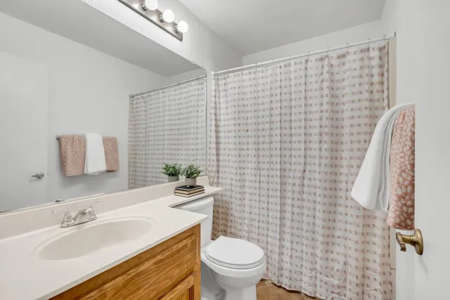 a bathroom with a sink a toilet and shower curtain