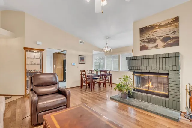 a living room with furniture a fireplace and a floor to ceiling window
