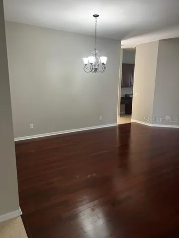 a view of a room with wooden floor and chandelier