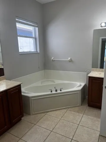 a spacious bathroom with a bathtub and a sink