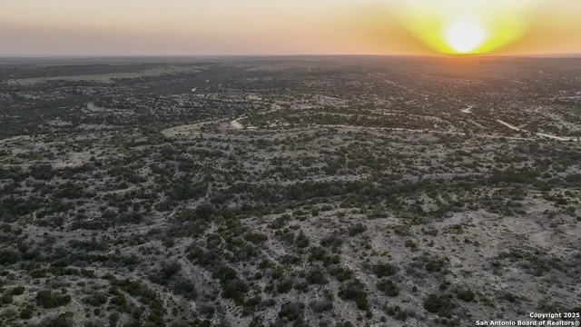 an aerial view of house with yard and mountain view in back