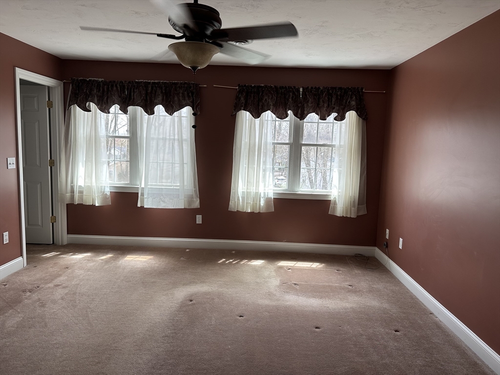 4 Village Way, Unit 4 Rutland, MA 01543 - Photo 15 of 33 an empty room with windows and a ceiling fan