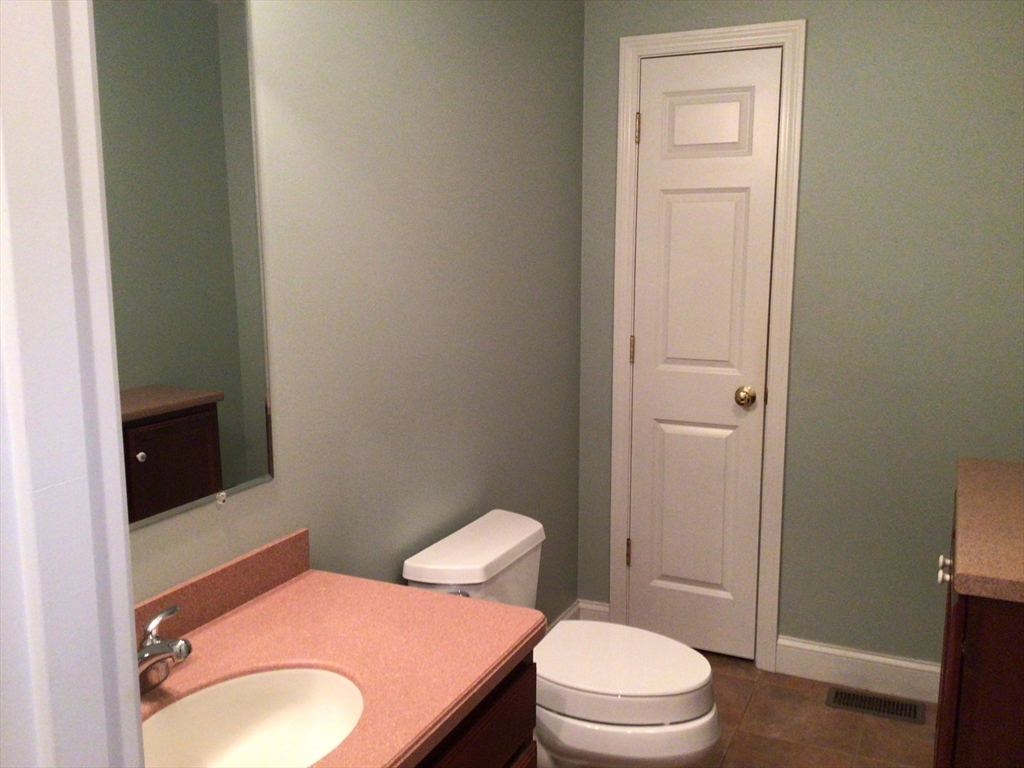 4 Village Way, Unit 4 Rutland, MA 01543 - Photo 27 of 33 a white toilet sitting next to a bathroom sink and vanity
