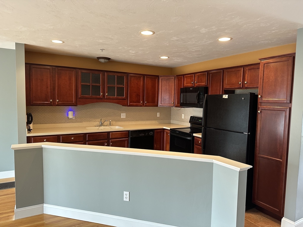 4 Village Way, Unit 4 Rutland, MA 01543 - Photo 6 of 33 a kitchen with stainless steel appliances granite countertop a refrigerator and a sink