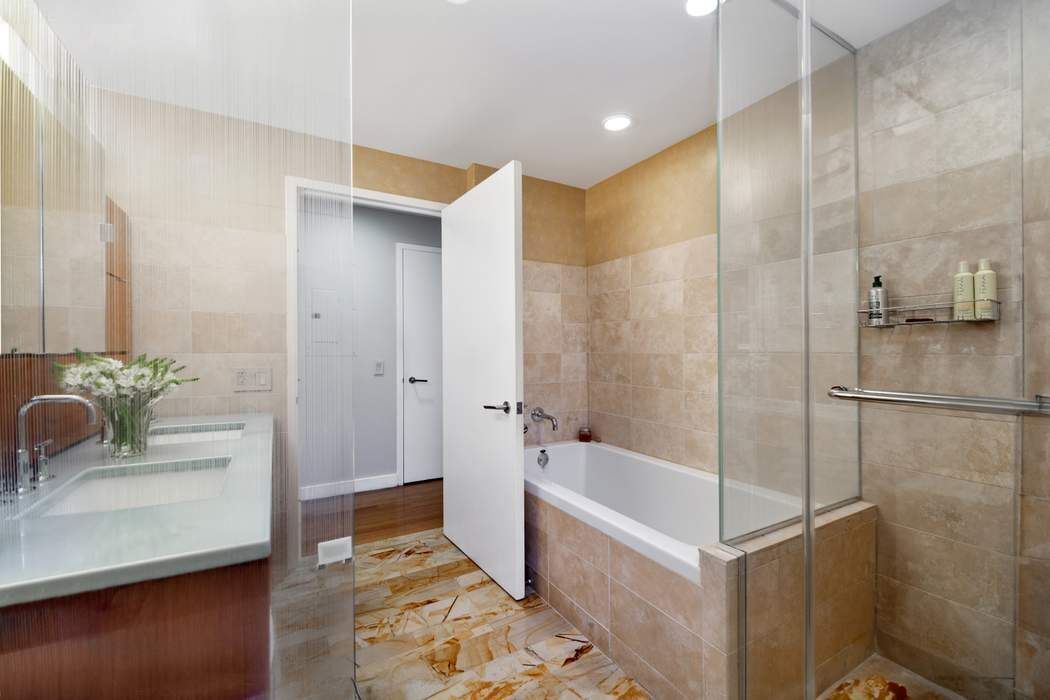 2 River Terrace, Unit 3B Manhattan, NY 10282 - Photo 5 of 8 a bathroom with a tub shower and sink