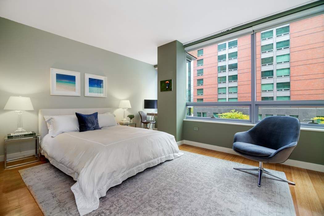 2 River Terrace, Unit 3B Manhattan, NY 10282 - Photo 6 of 8 a bedroom with a bed chair and a large window