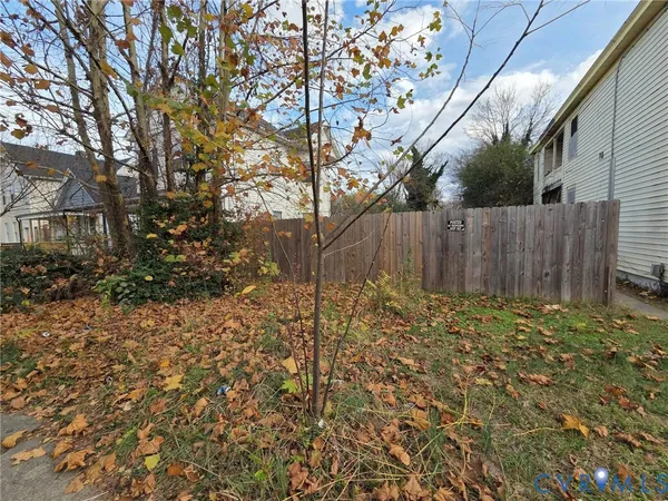 a view of backyard with wooden fence