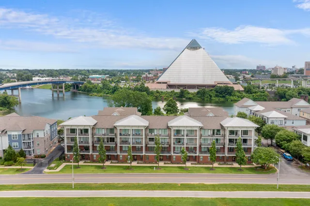 a view of a big house with a big yard and large trees