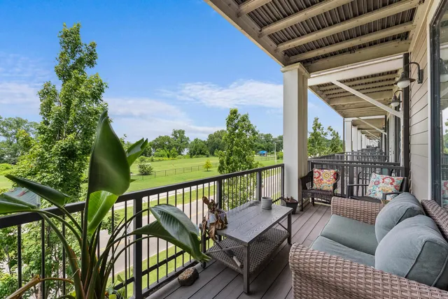 a balcony with wooden floor outdoor seating and stairs