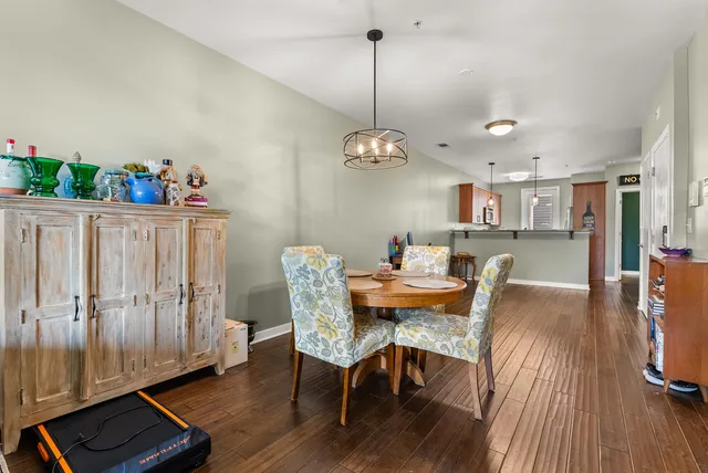 a dining room with furniture a chandelier and wooden floor