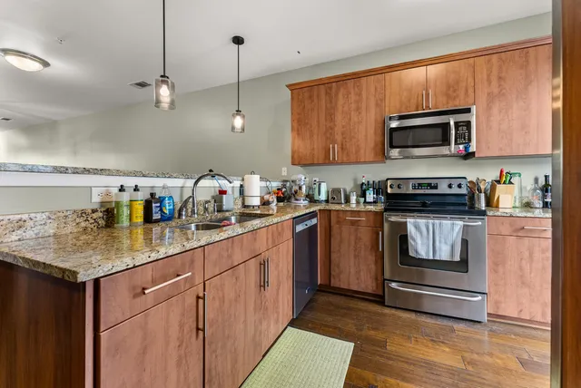 a kitchen with stainless steel appliances granite countertop a stove microwave and sink