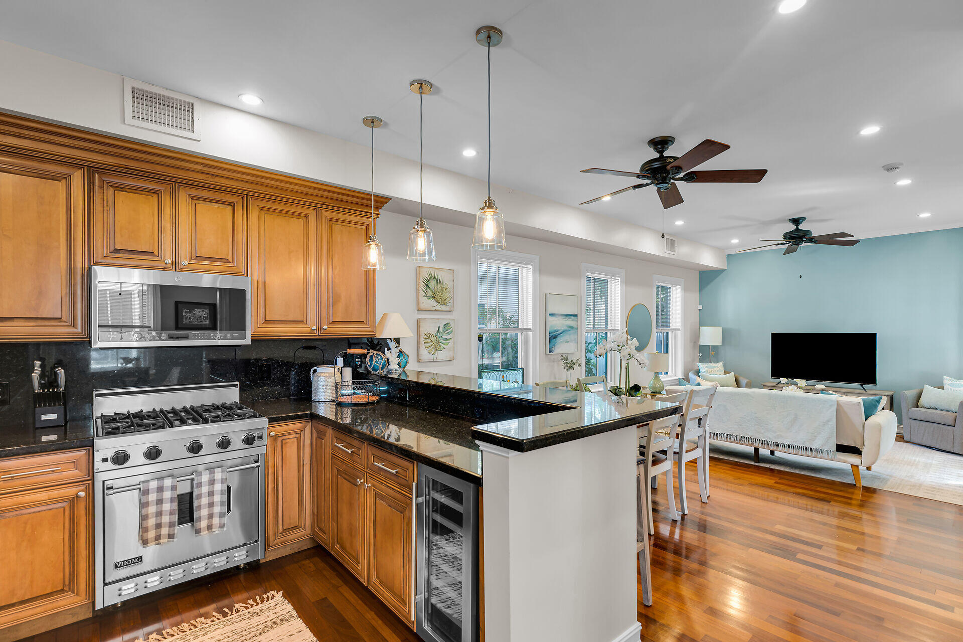713 Emma Street, Unit 1 Key West, FL 33040 - Photo 15 of 42 a kitchen with stainless steel appliances kitchen island granite countertop a stove top oven a sink a dining table and chairs with wooden floor