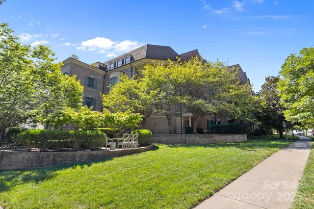 a view of a house with a yard and potted plants