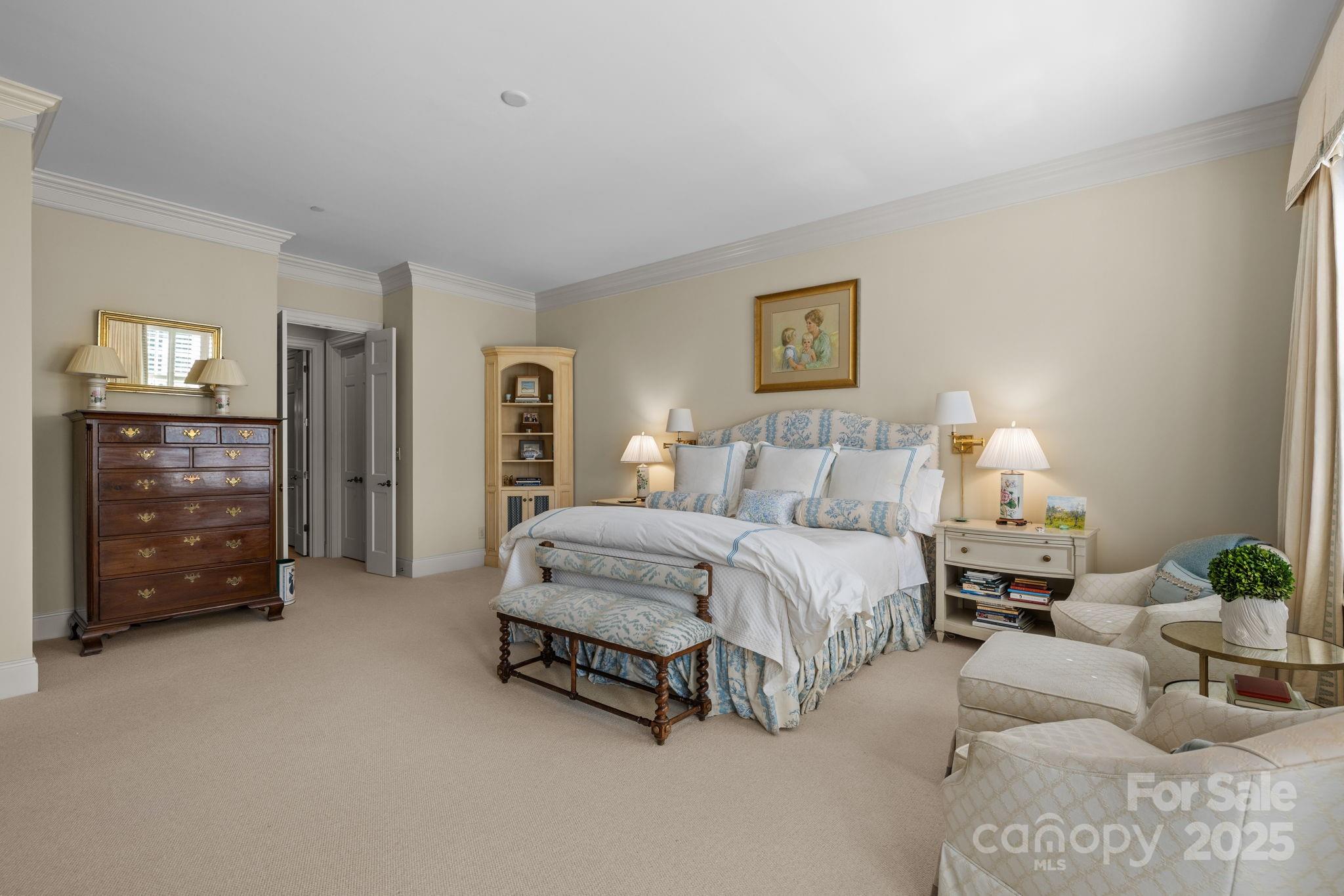 168 Cherokee Road Charlotte, NC 28207 - Photo 25 of 44 a spacious bedroom with a bed a couch and a chandelier