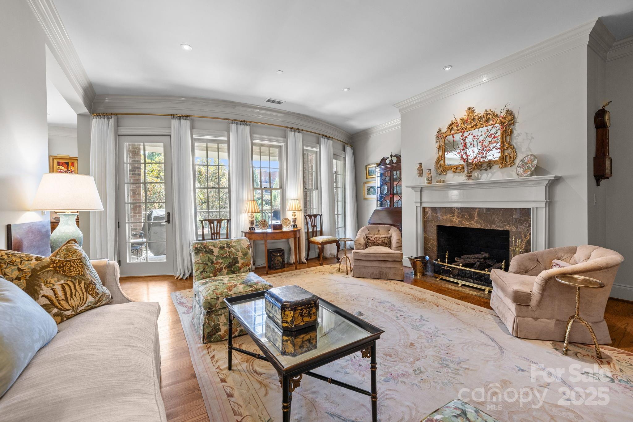 168 Cherokee Road Charlotte, NC 28207 - Photo 9 of 44 a living room with furniture a rug a fireplace and a large window