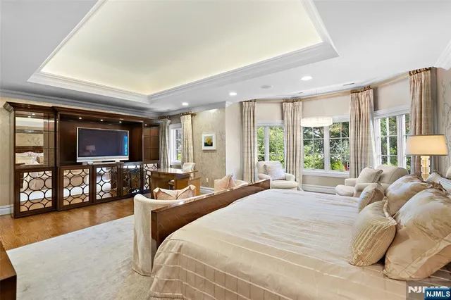 a bedroom with a bed and large windows