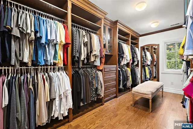 a view of walk in closet with clothes and shoes