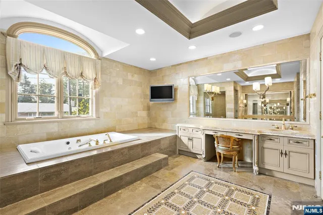a bathroom with a sink a large mirror and a bathtub