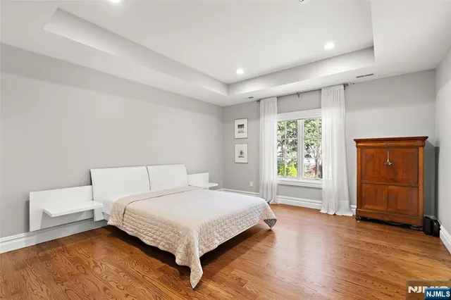 a bedroom with a large bed and wooden floor