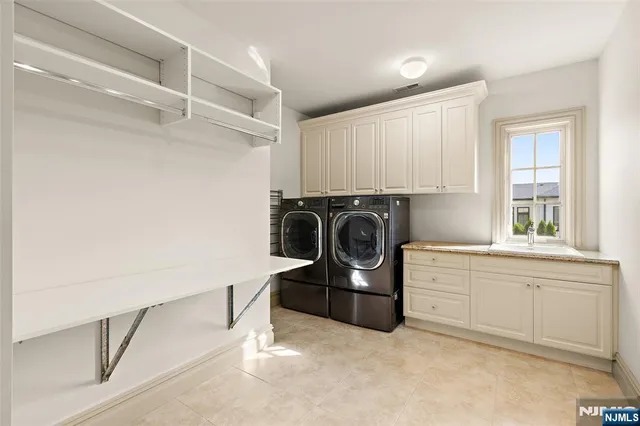 a utility room with sink dryer and washer