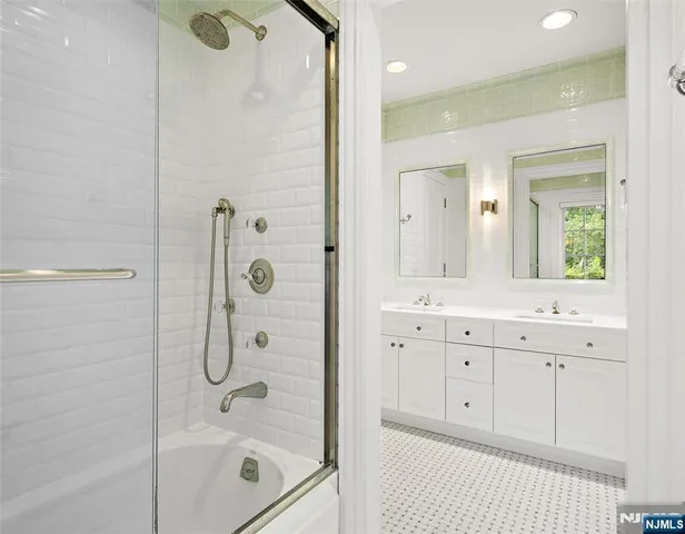 a bathroom with a shower a sink and mirror