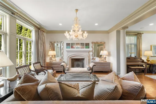a living room with furniture a chandelier and a large window