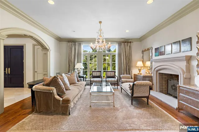 a living room with furniture fireplace and large windows