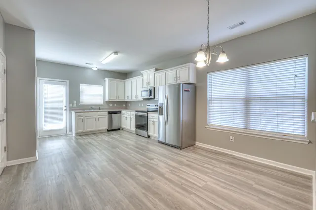 a view of kitchen with granite countertop cabinets and refrigerator
