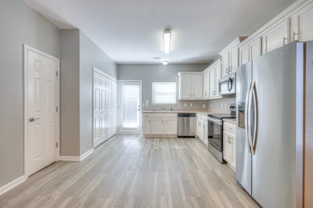 a kitchen with a refrigerator a sink and cabinets