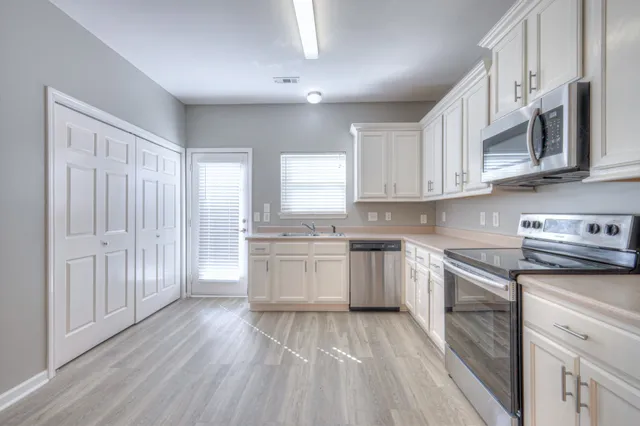 a kitchen with granite countertop white cabinets and white appliances
