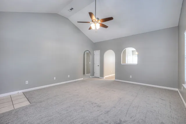 an empty room with fan and windows