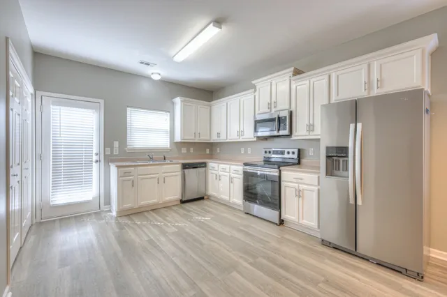 a kitchen with white cabinets and white appliances