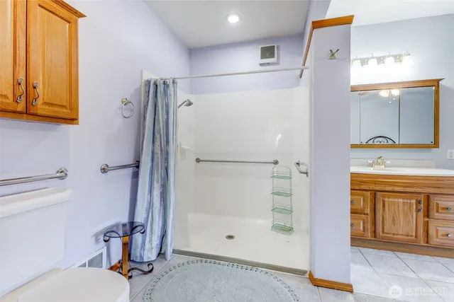 a bathroom with a granite countertop sink mirror and shower