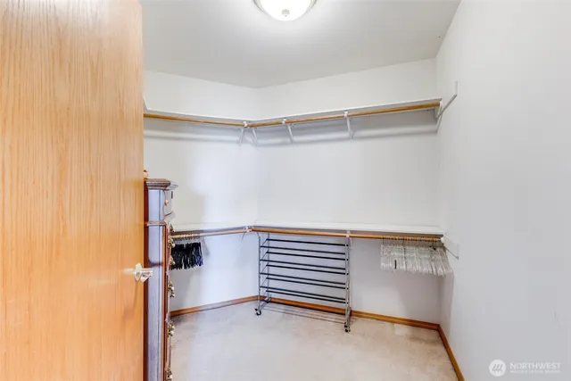 a view of walk in closet with clothes and shoes