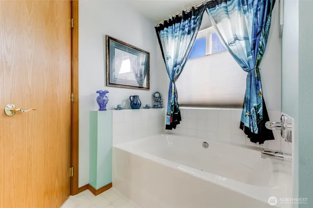 a bathroom with a bathtub sink and mirror