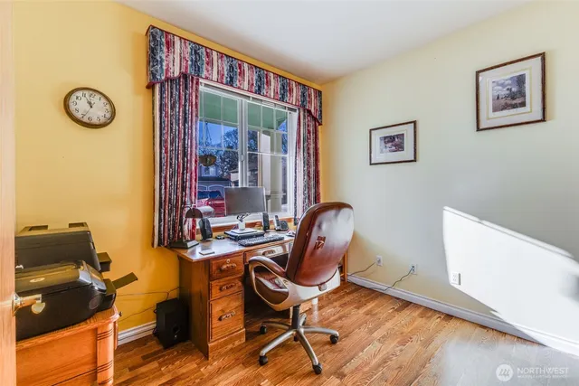 a view of a workspace with furniture and wooden floor