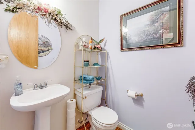a bathroom with a toilet a sink and mirror