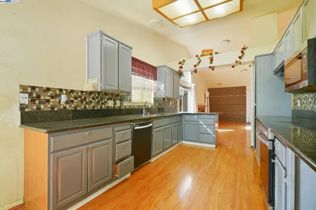a large kitchen with stainless steel appliances granite countertop a stove and a sink