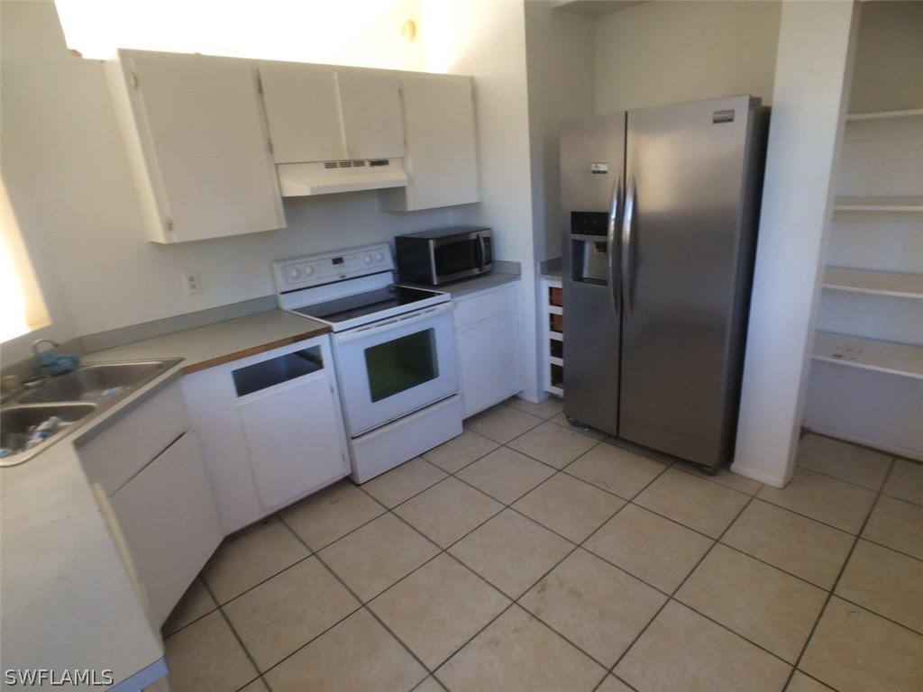 18250 Apple Road Fort Myers, FL 33967 - Photo 4 of 19 a kitchen with stainless steel appliances granite countertop a refrigerator a stove and a sink
