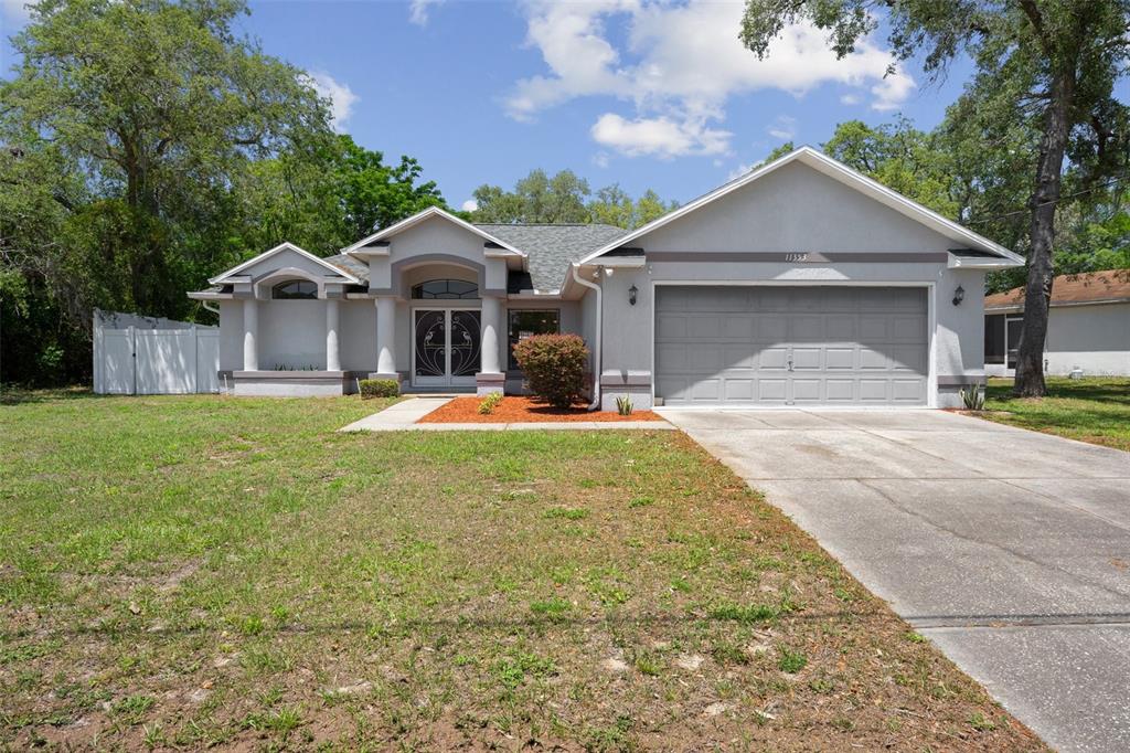 11353 Norvell Road Spring Hill, FL 34608 - Photo 1 of 1 a front view of a house with yard and green space