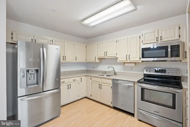 a kitchen with cabinets stainless steel appliances and a window