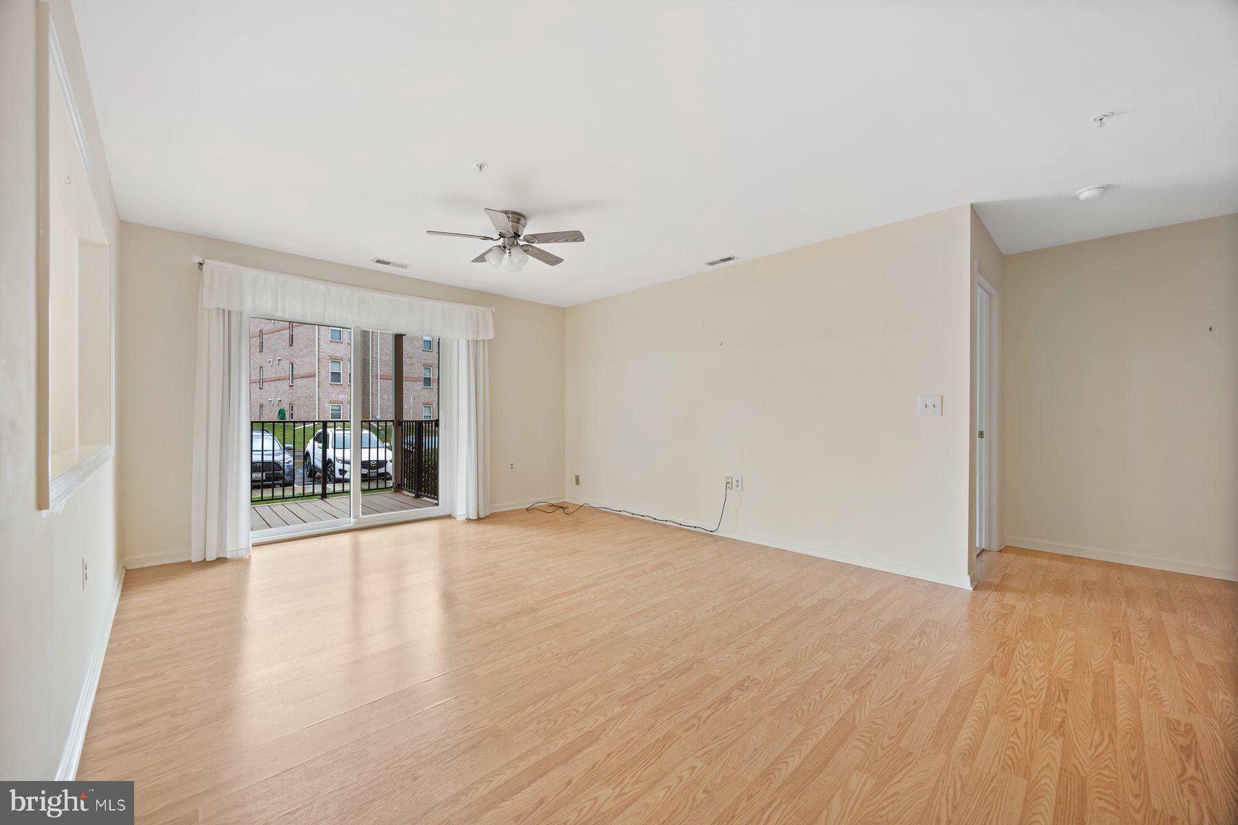 3901 Darleigh Road, Unit 1E Nottingham, MD 21236 - Photo 3 of 27 a view of an empty room with wooden floor and a window