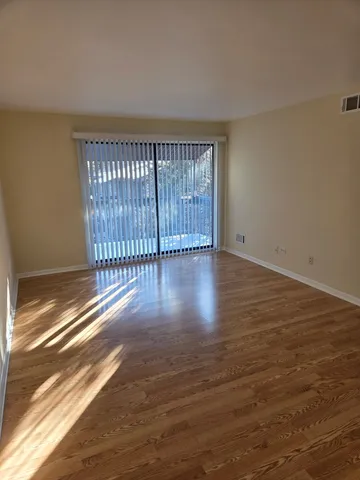 a view of an empty room with wooden floor