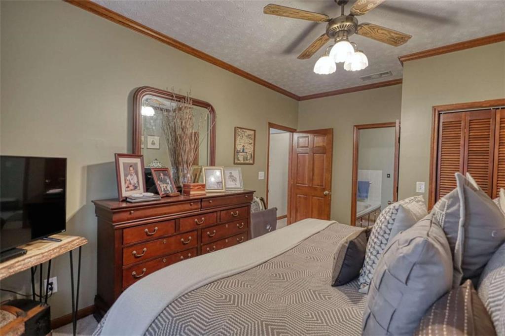 1665 County Line Road Mansfield, GA 30055 - Photo 49 of 74 a bedroom with a bed and a chandelier