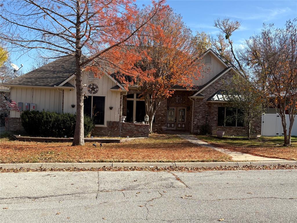 a view of a house with street that has a tree