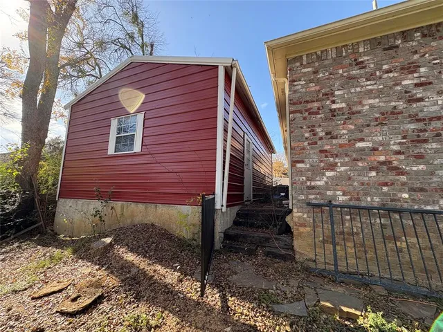 a view of a house with a small yard and wooden floor and fence