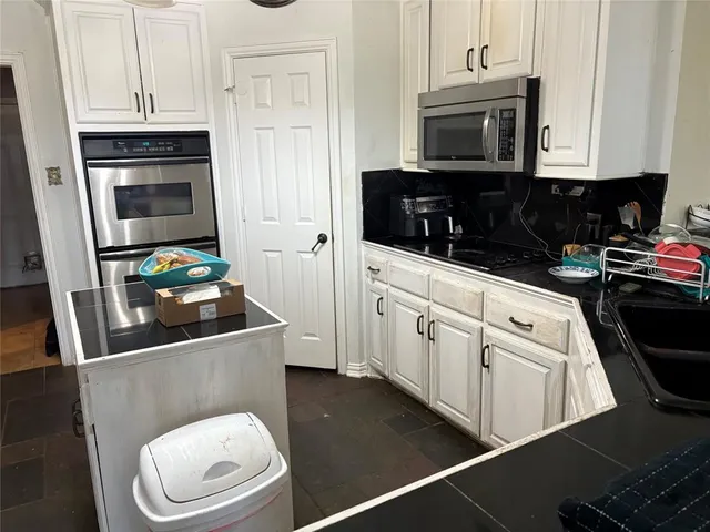 a kitchen with stainless steel appliances a stove a microwave and cabinets