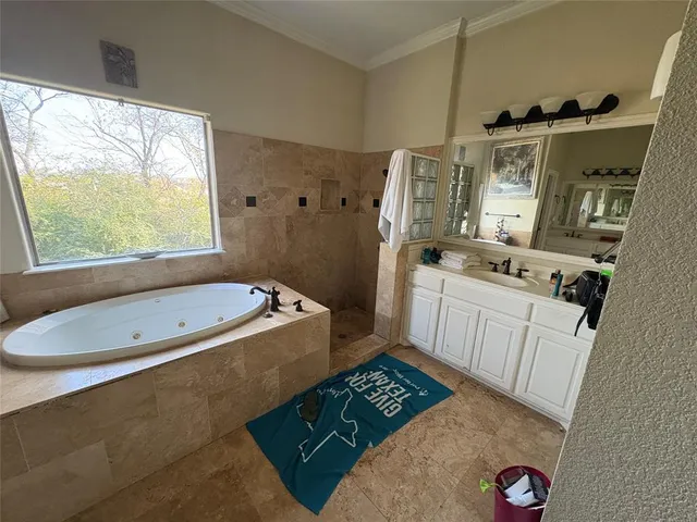 a bathroom with a tub a sink and a window