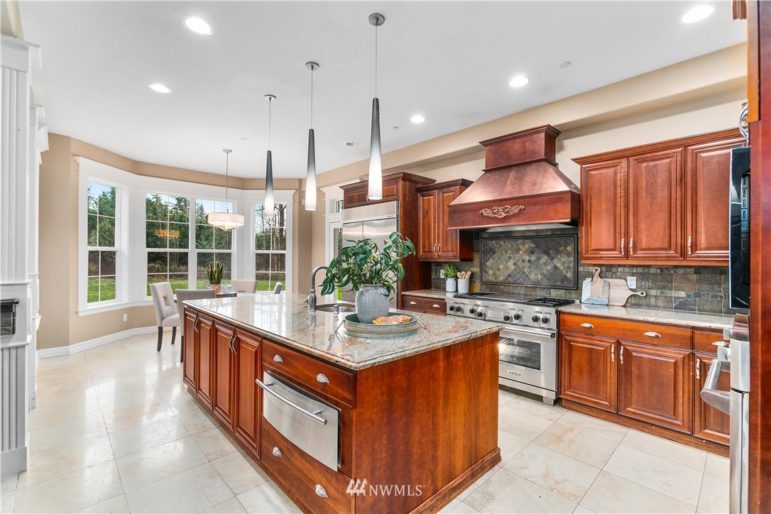 20630 Southeast 216th Street Maple Valley, WA 98038 - Photo 15 of 40 a kitchen with stainless steel appliances granite countertop a stove a sink dishwasher and a refrigerator